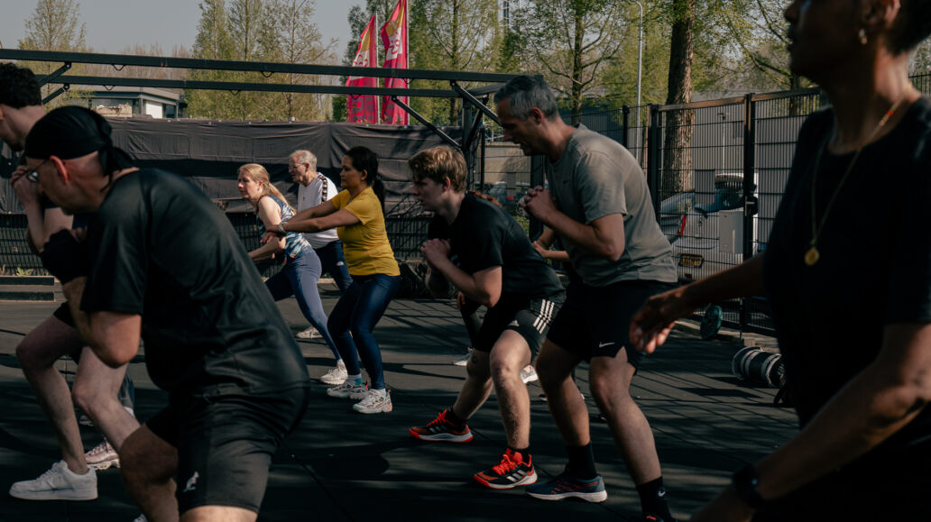 Een groep deelnemers doet samen een training in de buitenruimte van Intense